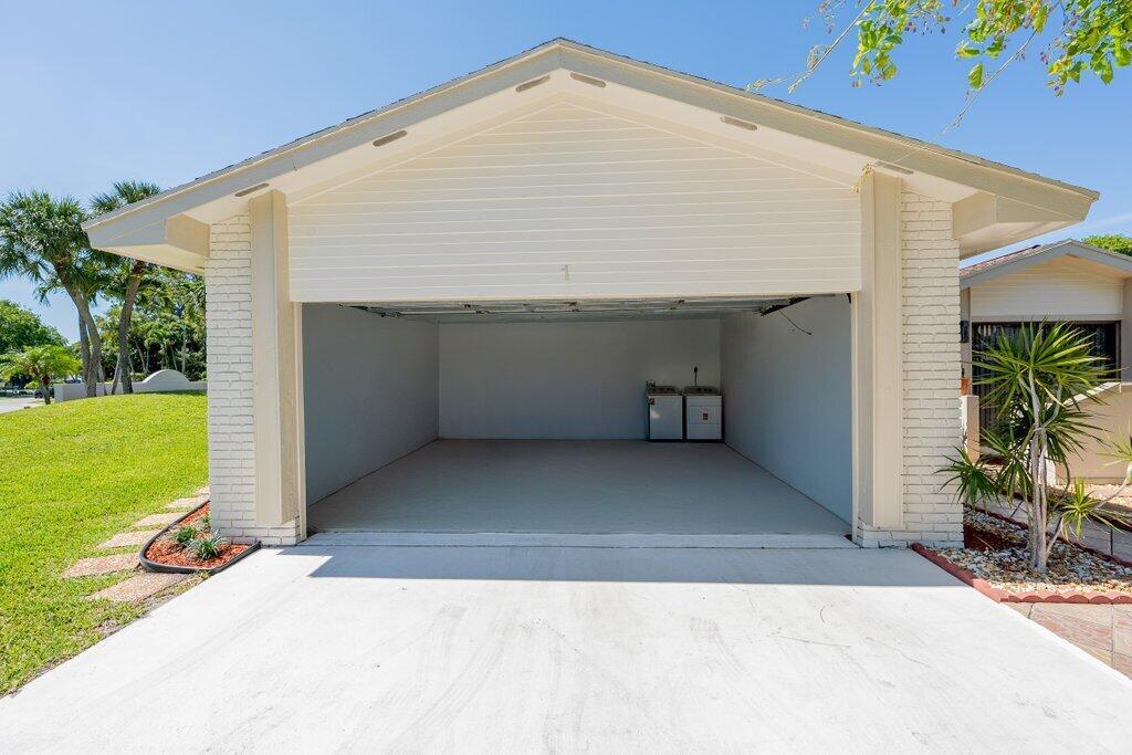An open-air garage with a concrete floor and a white exterior wall — 1 Afton Place, Boynton Beach FL 33426, BOYNTON BEACH, FL
