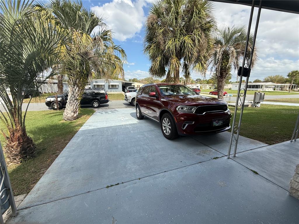 A maroon SUV is parked on a concrete driveway in front of a mobile home — 7441 FAIRLANE AVENUE, BROOKSVILLE, FL
