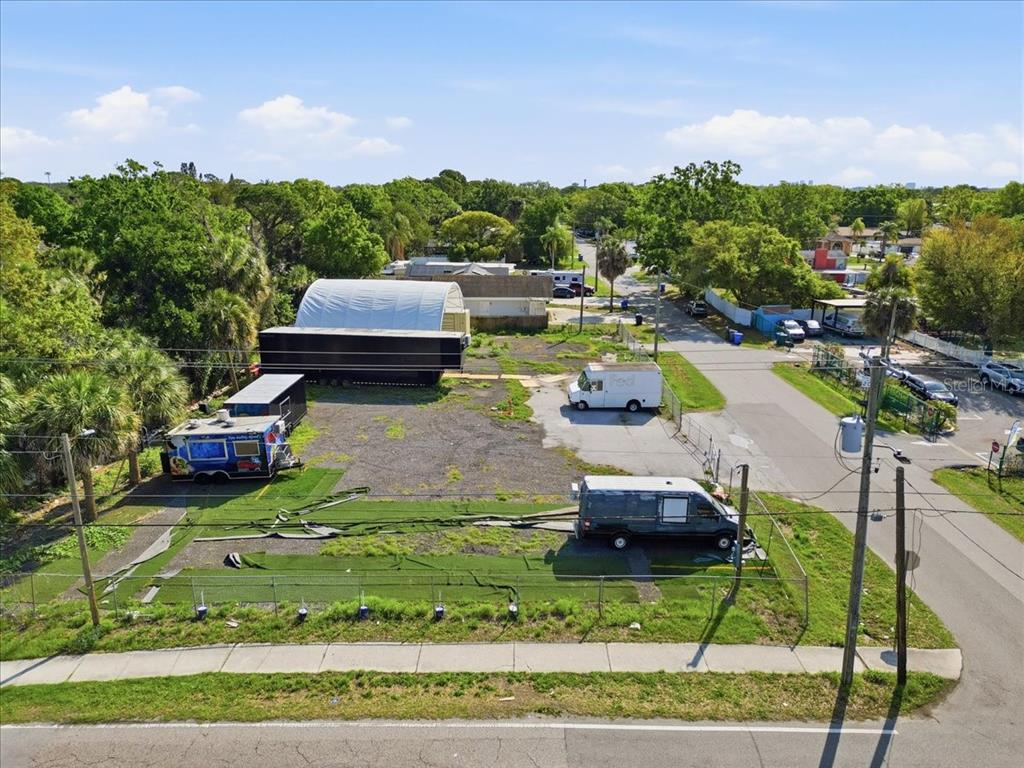 An aerial view shows a fenced, gravel-covered lot with several trailers and a storage structure — 7511 WINCHESTER DRIVE, TAMPA, FL