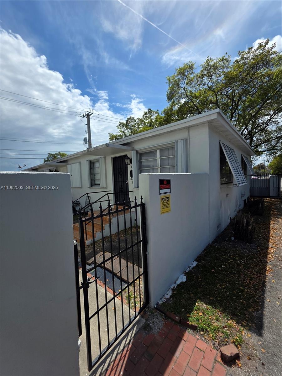 A white single-story building features a gated entrance and a no trespassing sign — 57 Esplanade Dr # C, Miami Springs FL 33166, MIAMI SPRINGS, FL