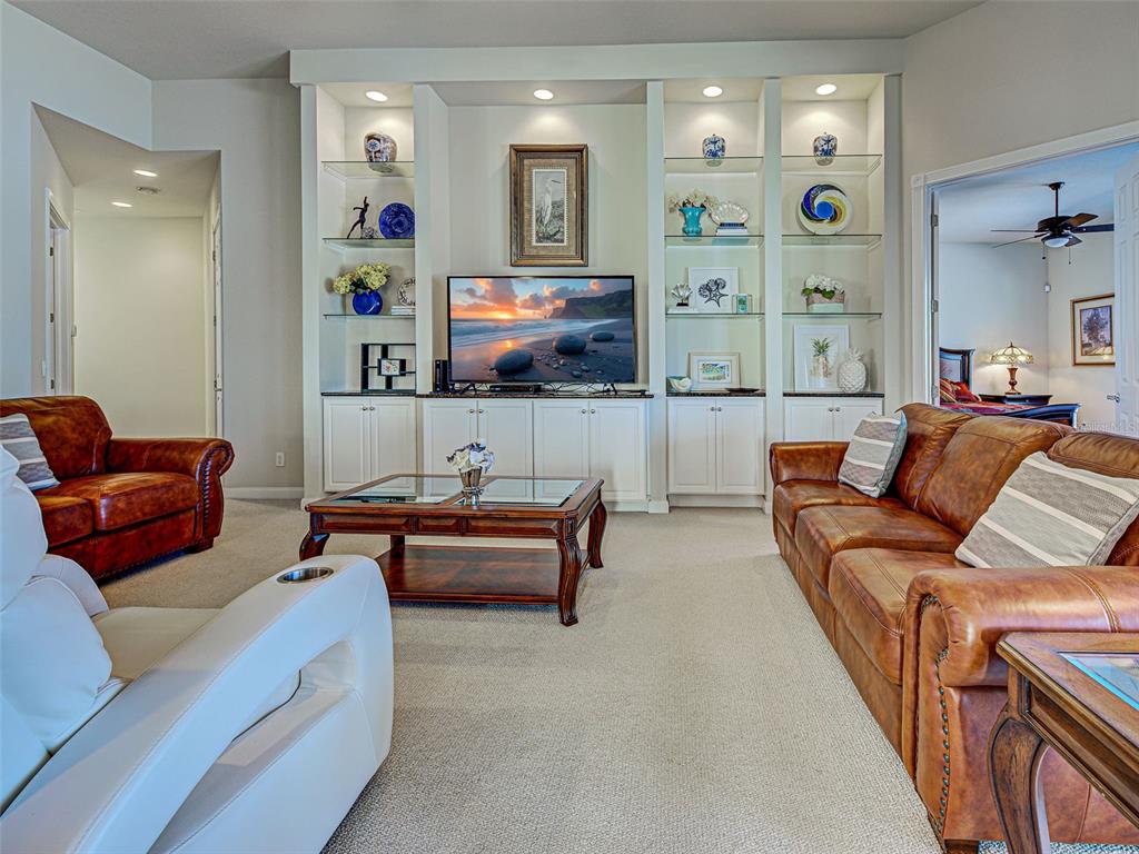 A living room features a built-in entertainment center, leather sofas, and a coffee table — 19267 KIRELLA STREET, VENICE, FL