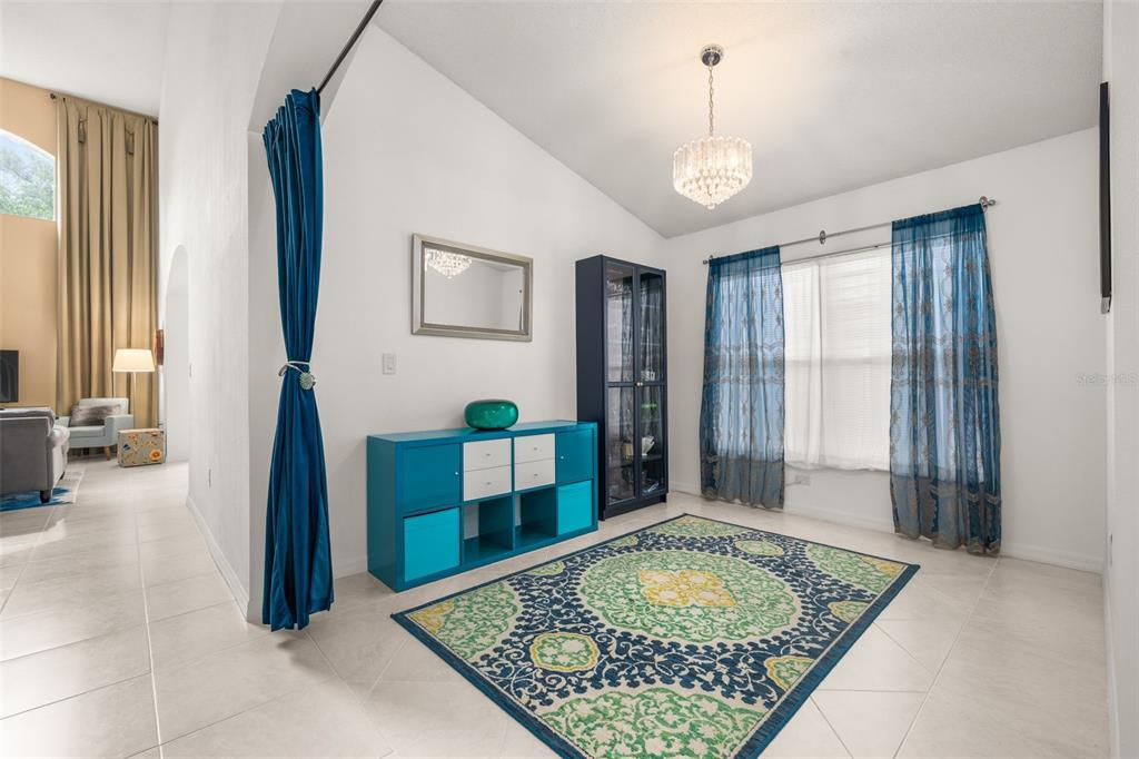 A room with tile floors, a patterned rug, blue storage furniture, and blue curtains — 4638 RAINTREE RIDGE ROAD, ORLANDO, FL