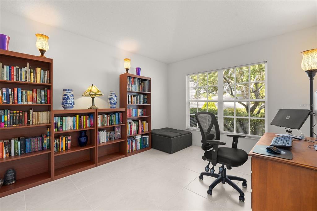 A home office features tile flooring, multiple wooden bookshelves, a desk, and a window — 4638 RAINTREE RIDGE ROAD, ORLANDO, FL