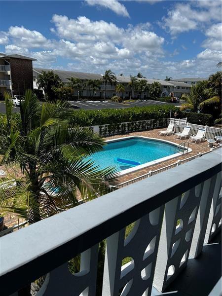 An elevated view of a swimming pool surrounded by lounge chairs and palm trees — 701 Pine Drive # 204, Pompano Beach FL 33060, POMPANO BEACH, FL