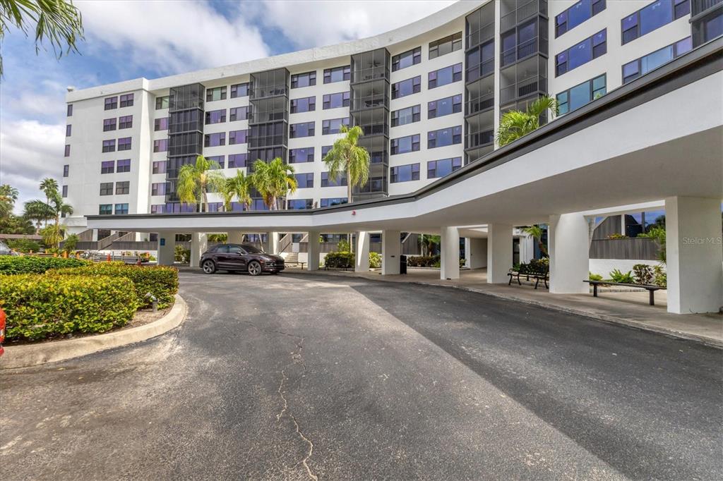 A multi-story apartment building with a curved facade and a covered driveway entrance — 5855 MIDNIGHT PASS ROAD UNIT 420, SARASOTA, FL