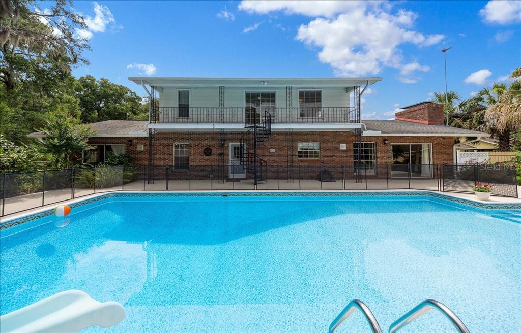 A two-story brick house with a balcony and spiral staircase overlooks a backyard swimming pool — 2300 SE 38TH COURT, OCALA, FL