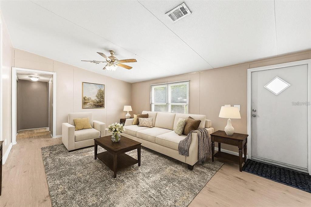 A living room features a beige sofa, an armchair, a coffee table, and light flooring — 201 N 5TH STREET, ORLANDO, FL