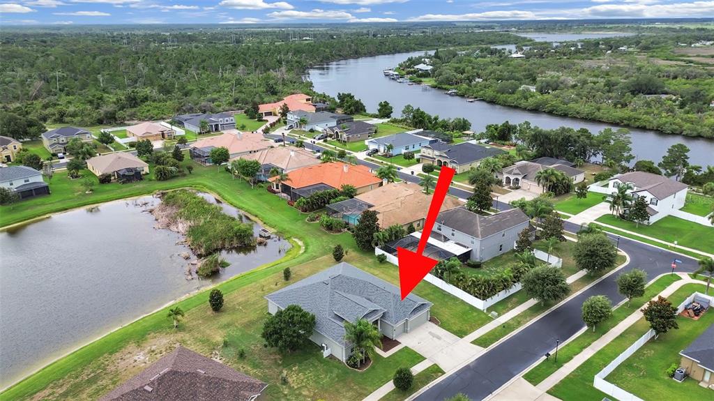 An aerial view shows a single-story house with a gray roof near a pond — 2422 ALLEGHENY VALLEY STREET, RUSKIN, FL