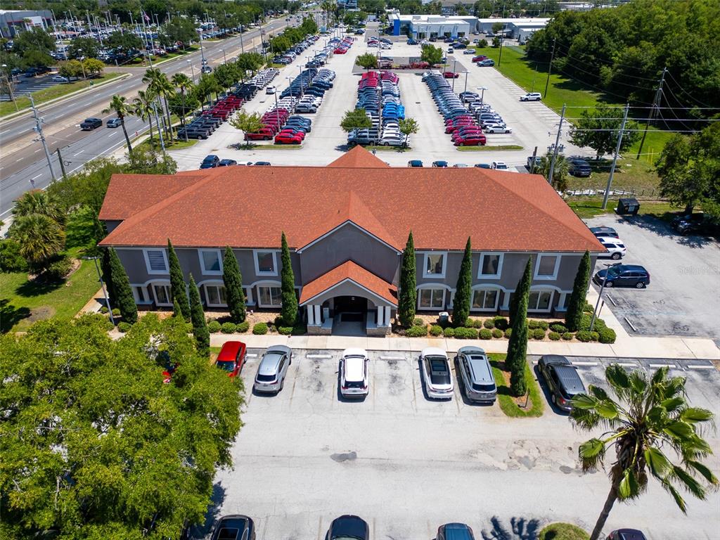 An aerial view shows a two-story commercial building with a red roof and parking lot — 11183 S ORANGE BLOSSOM TRAIL UNIT 103 / 102, ORLANDO, FL