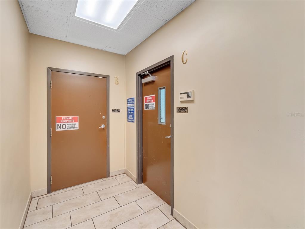 Two brown doors labeled B and C are set in a hallway with tiled floors — 11183 S ORANGE BLOSSOM TRAIL UNIT 103 / 102, ORLANDO, FL