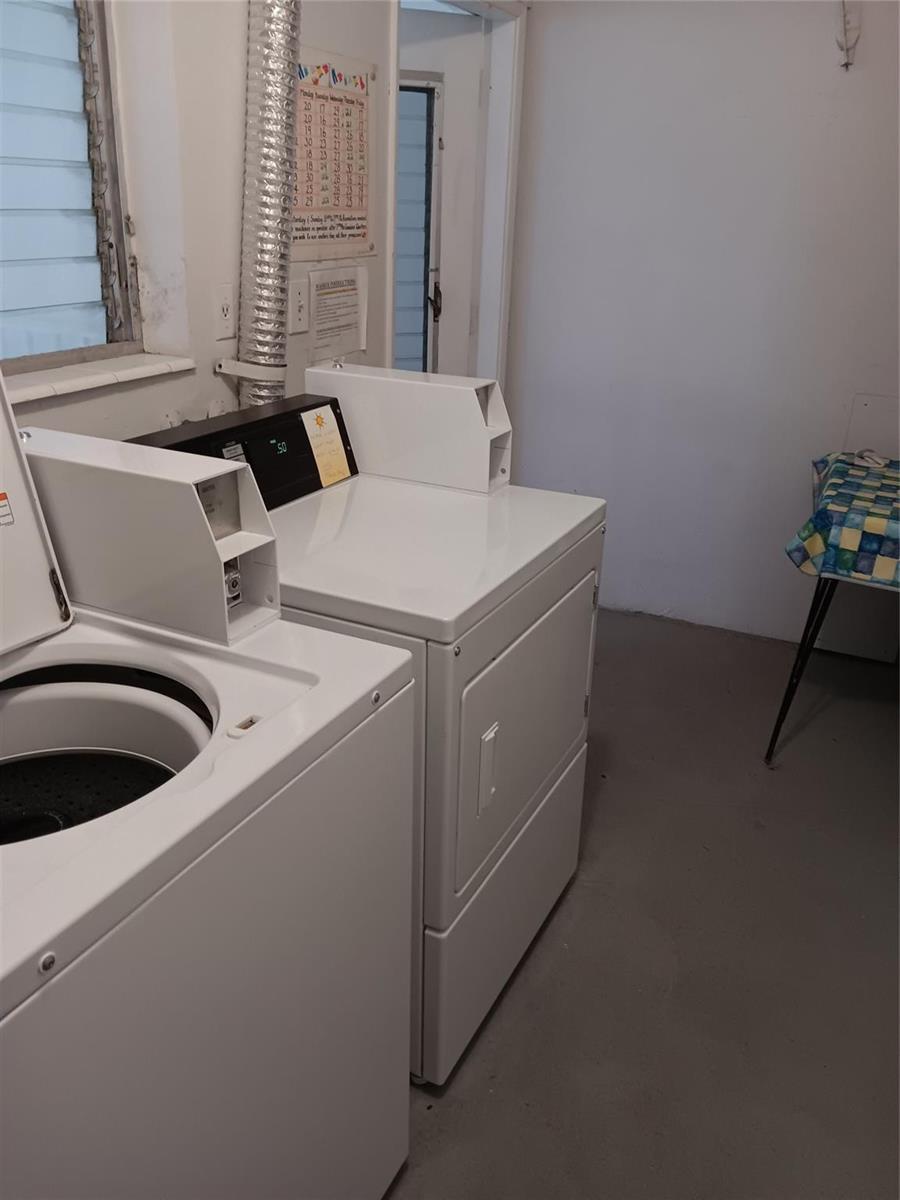 A laundry room features a white top-loading washing machine and a matching dryer — 1110 N Riverside Drive # 26, Pompano Beach FL 33062, POMPANO BEACH, FL