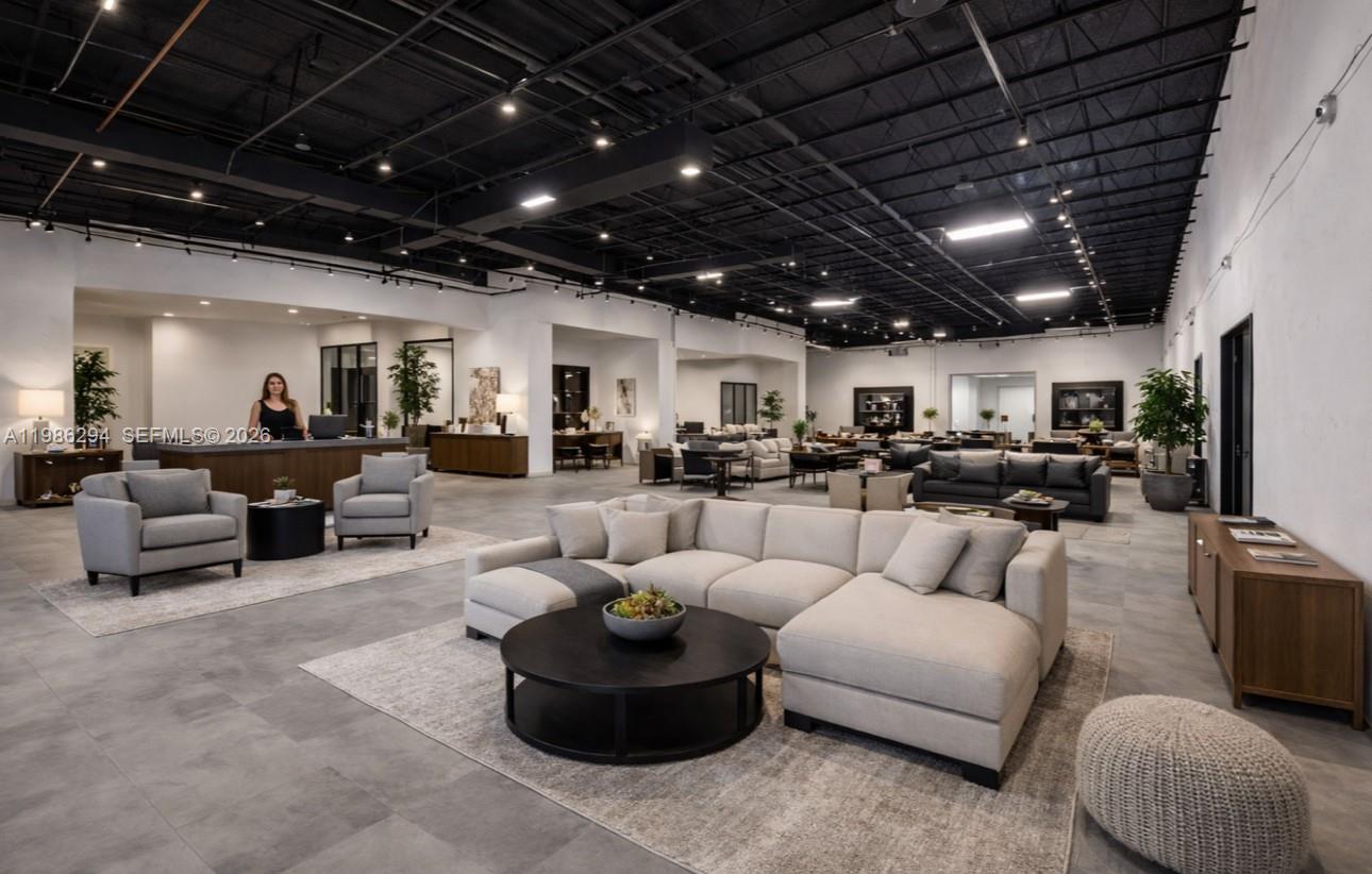 A spacious, open-concept furniture showroom features neutral-toned seating areas, tile flooring, and exposed black ceilings — 2950 N 28th Ter, Hollywood FL 33020, HOLLYWOOD, FL