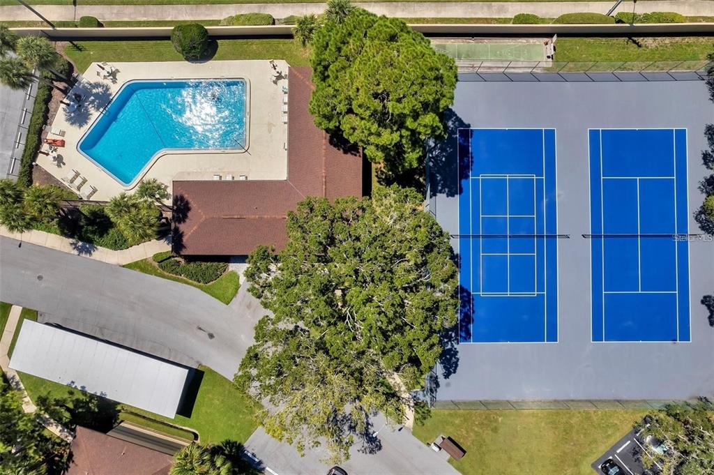 An aerial view shows a swimming pool, a clubhouse, and two tennis courts — 2682 SABAL SPRINGS CIRCLE UNIT 204, CLEARWATER, FL
