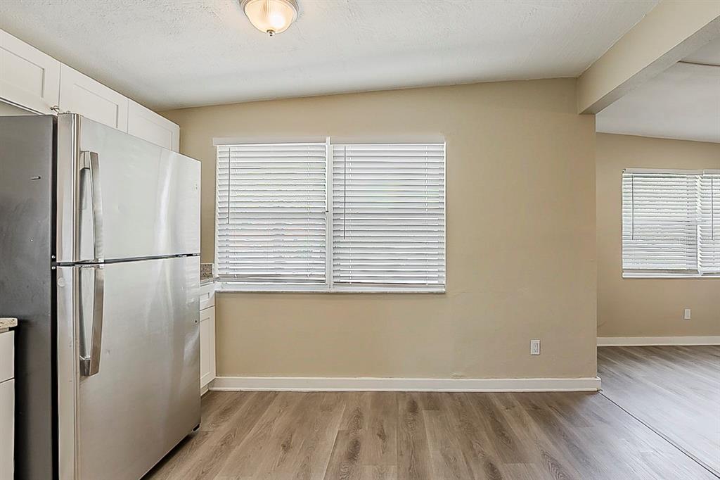 A kitchen with a stainless steel refrigerator, light-colored walls, and wood-look flooring — 4010 EMERSON AVENUE S, ST PETERSBURG, FL