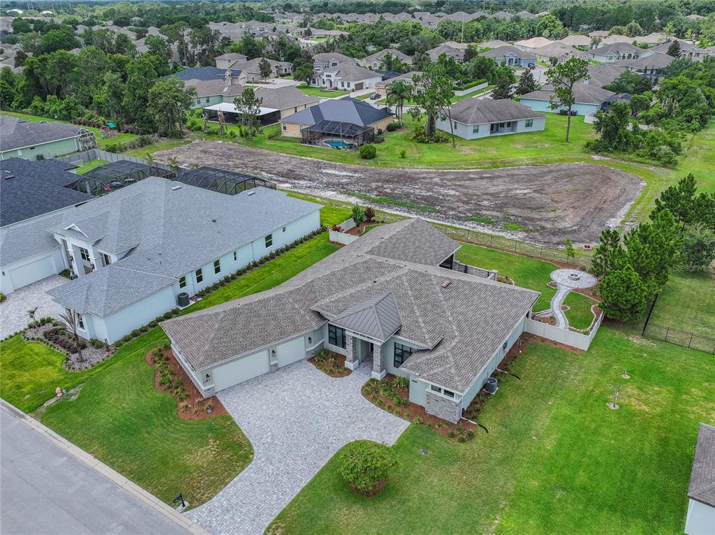 An aerial view shows a single-story house with a paved driveway and a large backyard — 6545 EMERALD WOODS LANE, LAKELAND, FL