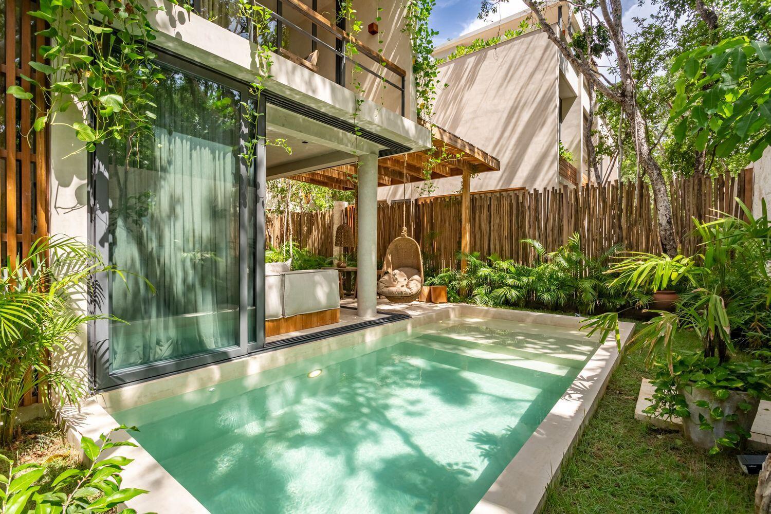 A modern villa features a private swimming pool, a hanging chair, and lush tropical landscaping — Amari Tulum 10 Avenida Norte & Calle Palma, FL