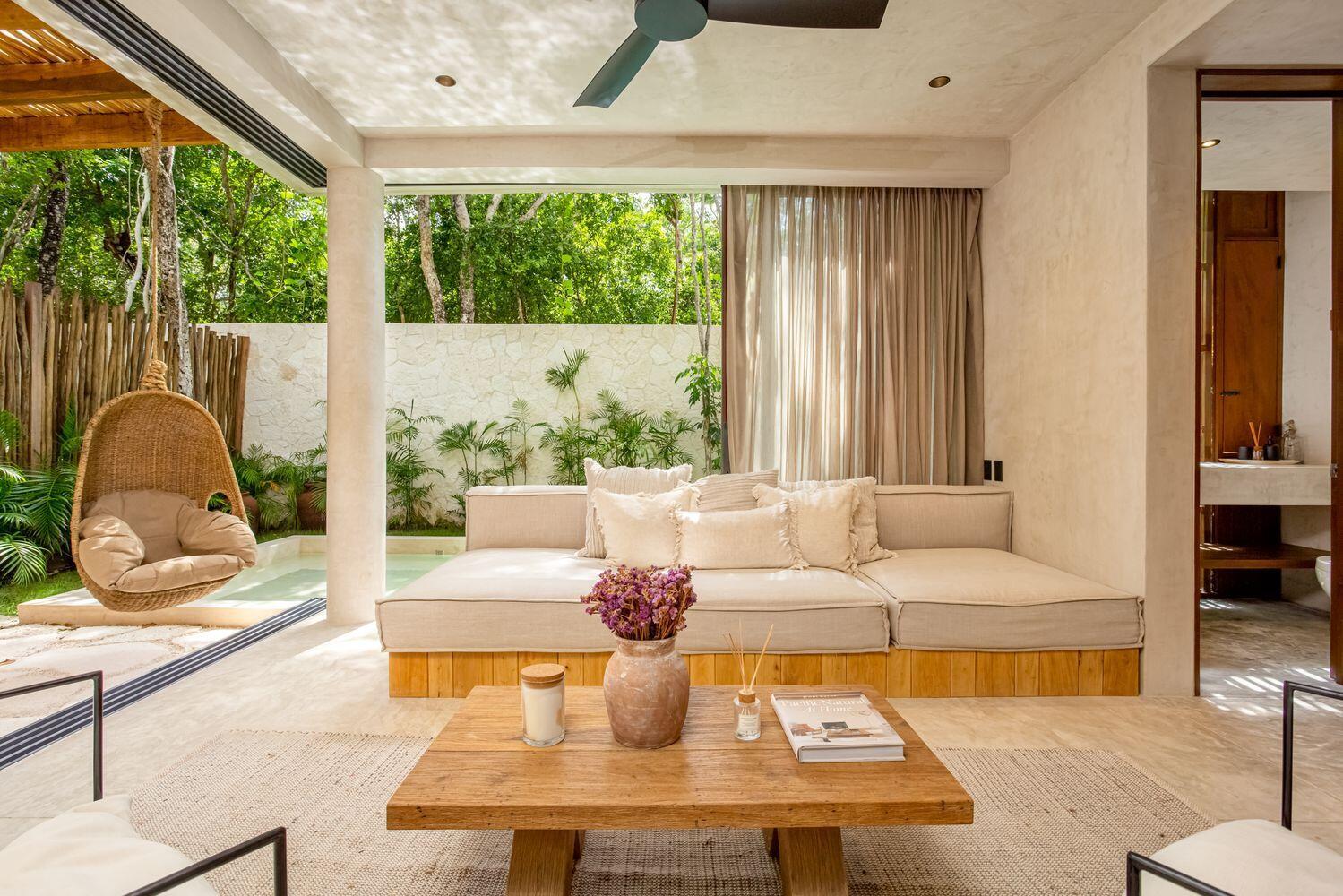 An open-air living room features a built-in sofa, wooden coffee table, and a hanging chair — Amari Tulum 10 Avenida Norte & Calle Palma, FL