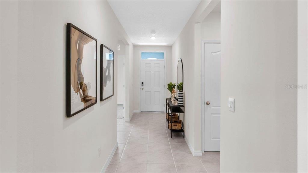 A bright entryway features light tile flooring, white walls, and a white front door — 3740 GIORGIO DRIVE, WINTER HAVEN, FL