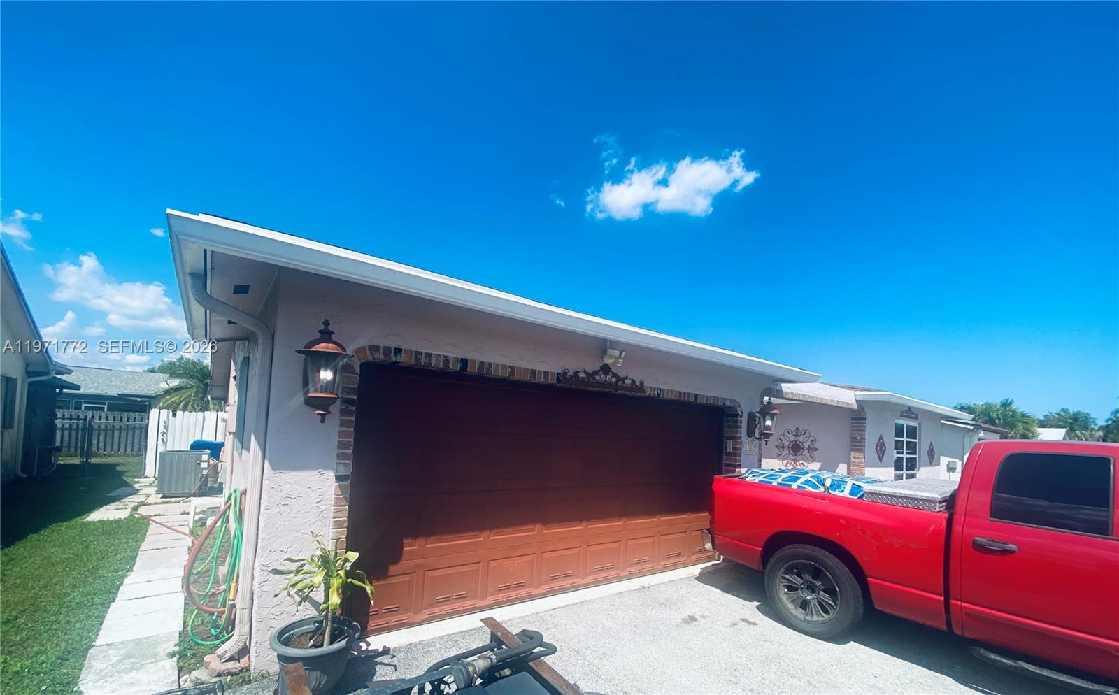 A red pickup truck is parked in the driveway in front of a garage — 11827 NW 39th St, Sunrise FL 33323, SUNRISE, FL