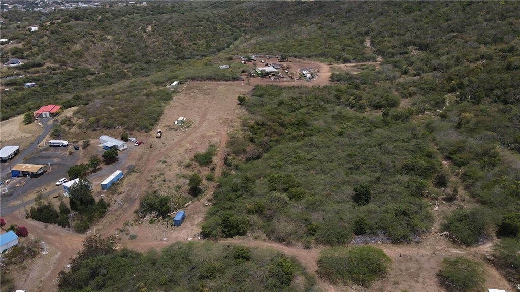 An aerial view shows a large, hilly plot of land with scattered structures and vegetation — PR 250 KM 2.5 BO FLAMENCO Y SAN ISIDRO, CULEBRA, PR