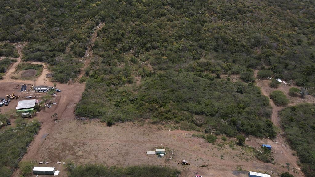 An aerial view shows a large, partially cleared plot of land with surrounding dense vegetation — PR 250 KM 2.5 BO FLAMENCO Y SAN ISIDRO, CULEBRA, PR