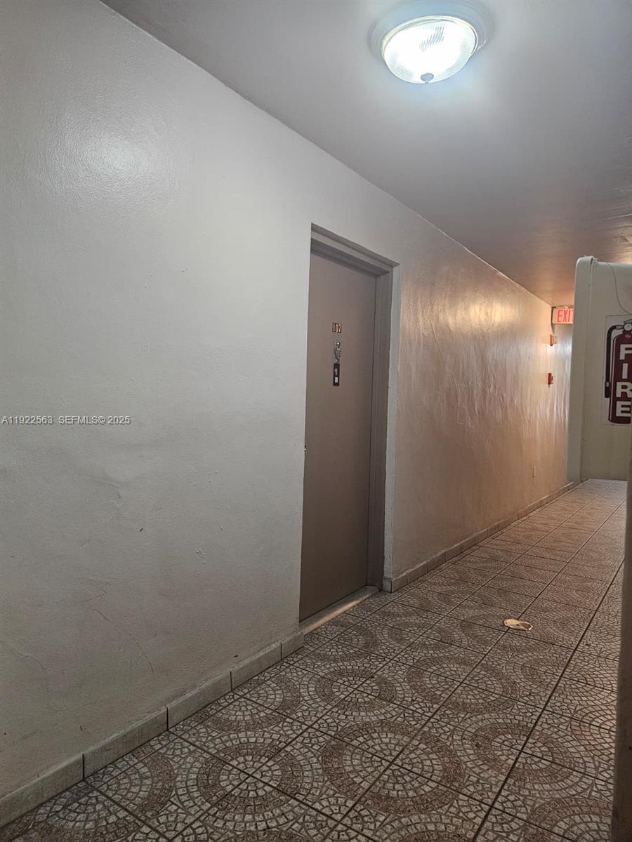 A tiled hallway features a single door labeled 107 and a ceiling light fixture — 8411 NW 8th St # 111, Miami FL 33126, MIAMI, FL