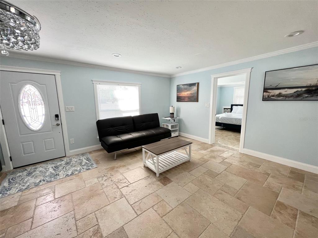 A living room features light blue walls, tile flooring, a black sofa, and a coffee table — 2963 BAHIA VISTA STREET, SARASOTA, FL