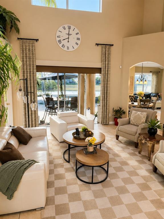 A living room features a checkered rug, white leather furniture, and a large wall clock — 1546 STARGAZER TERRACE, SANFORD, FL