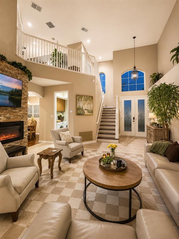 A living room features a stone fireplace, a staircase, and a view of the entryway — 1546 STARGAZER TERRACE, SANFORD, FL
