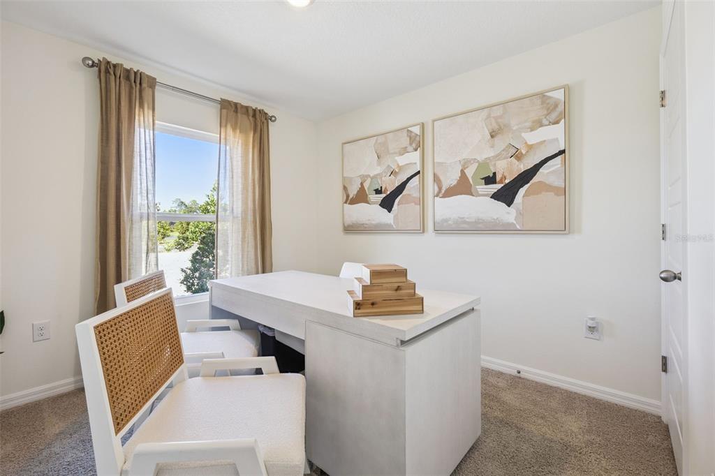 A home office features a white desk, two cane-back chairs, and abstract wall art — 1727 GRANDIOSE DRIVE, HAINES CITY, FL