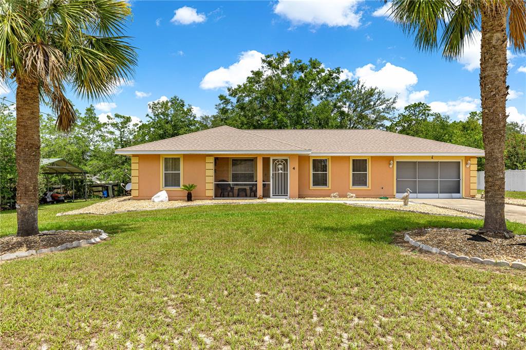 The exterior of a peach-colored house features a screened-in porch and a tiled walkway — 4 CEDAR TRACE PASS, OCALA, FL