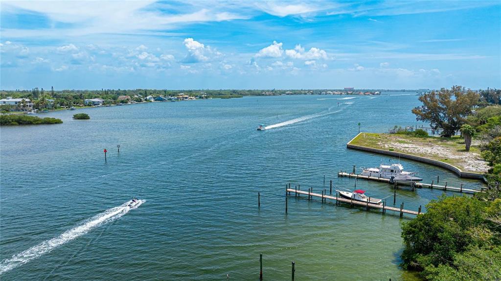 An aerial view of a waterway with boats, a wooden dock, and surrounding coastal vegetation — 1308 OLD STICKNEY POINT ROAD UNIT WP3, SARASOTA, FL