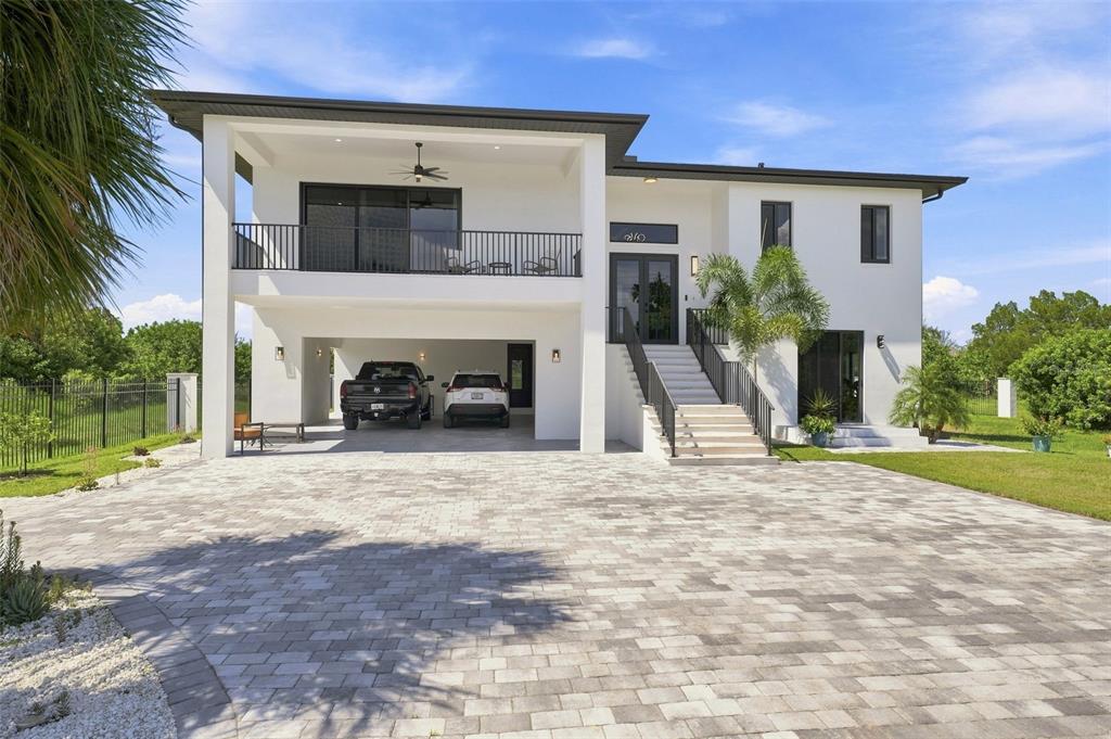 A modern two-story house with a covered ground-level parking area and an elevated front entrance — 5035 BAY BOULEVARD, PORT RICHEY, FL