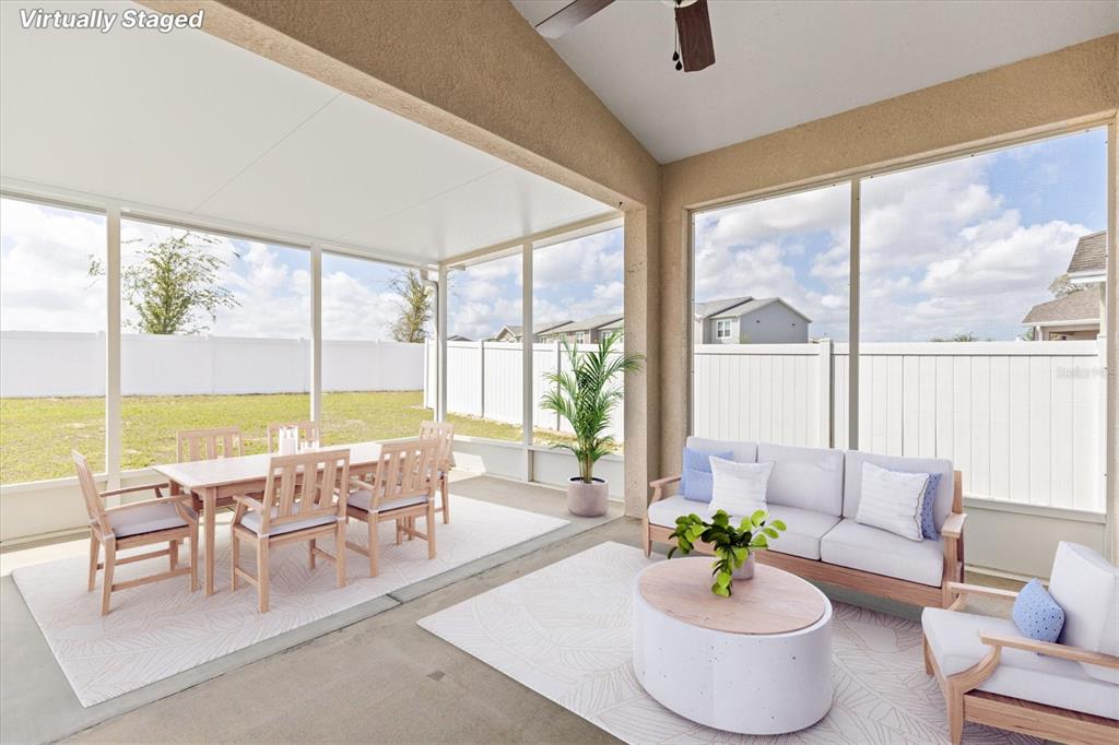 A covered, screened-in patio features a dining set and lounge furniture on a concrete floor — 601 NODDING SHADE DRIVE, BROOKSVILLE, FL