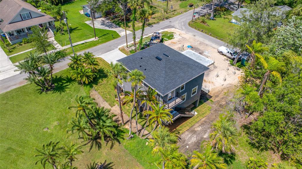 An aerial view shows a multi-story house with a dark roof surrounded by palm trees — 1004 W HENRY AVENUE, TAMPA, FL