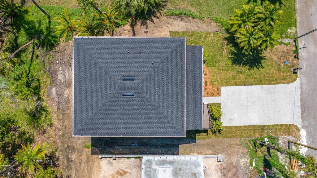 An aerial view shows a house with a dark shingled roof and a concrete driveway — 1004 W HENRY AVENUE, TAMPA, FL