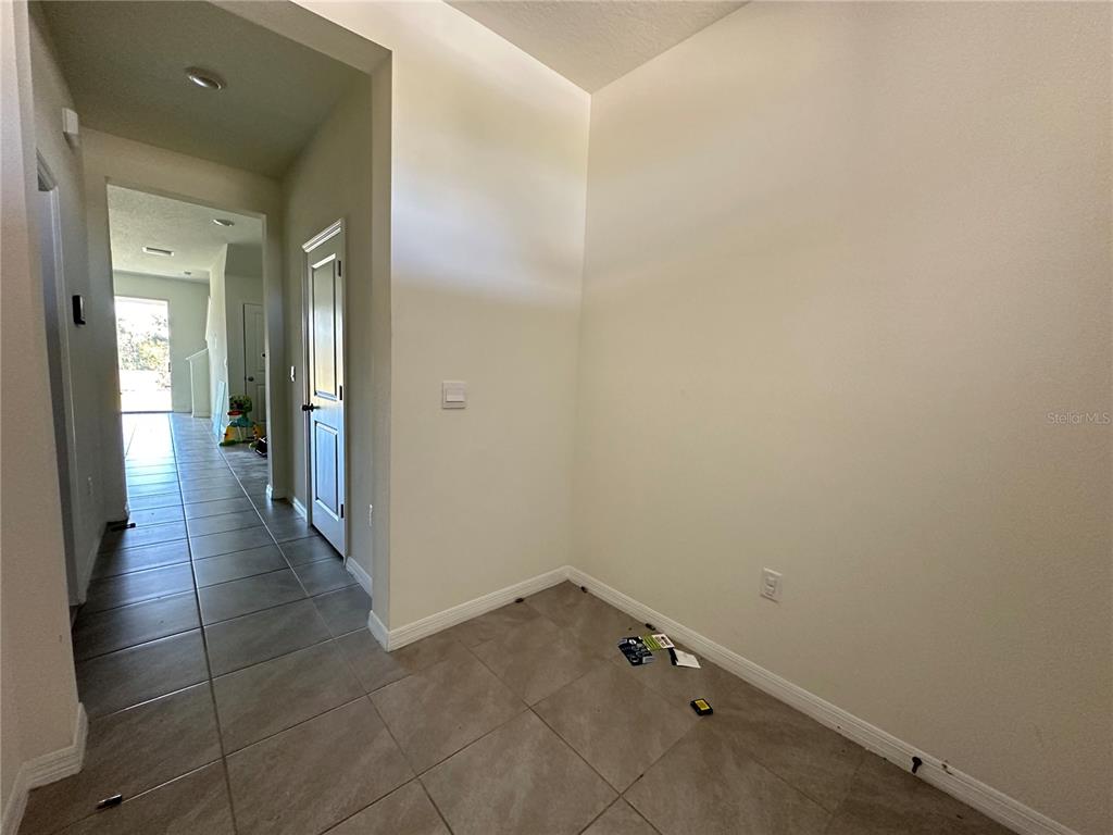 An interior view shows a tiled hallway leading to a doorway and a small alcove — 16641 GROTTO STEAM PLACE, WIMAUMA, FL