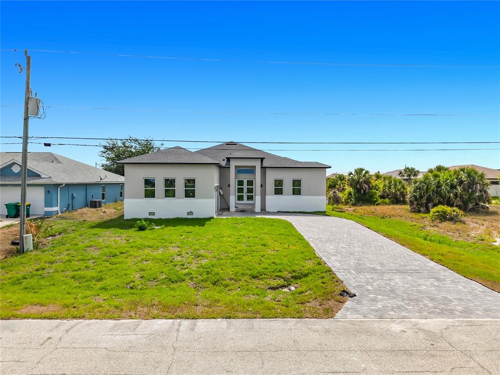 A single-story house with a gray and white exterior, a paver driveway, and a front entrance — 10262 KINGSVILLE DRIVE, PORT CHARLOTTE, FL