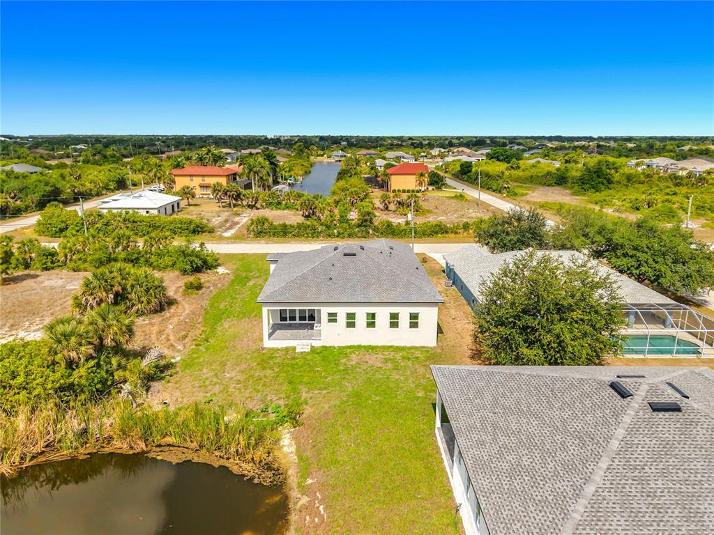 The exterior of a modern house features a paved driveway, a garage, and double doors — 10262 KINGSVILLE DRIVE, PORT CHARLOTTE, FL