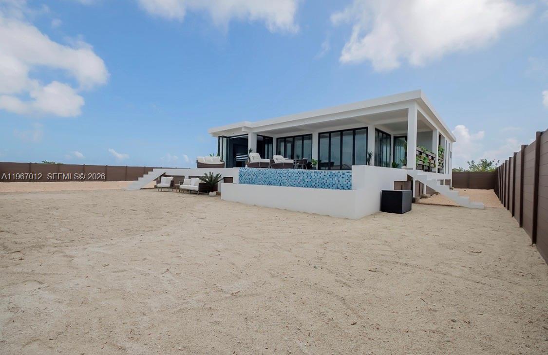 A modern white house with a pool and patio sits on a sandy lot — 42A Barrier Reef Drive, 00000, FL