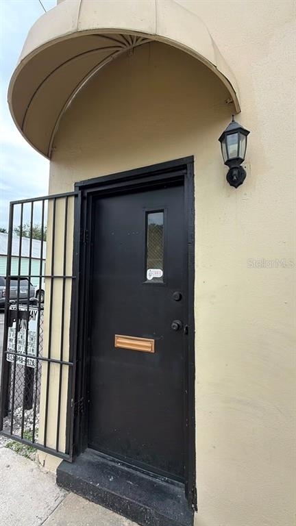 A black door with a small window and a metal security gate under an awning — 2115 N 22ND STREET, TAMPA, FL