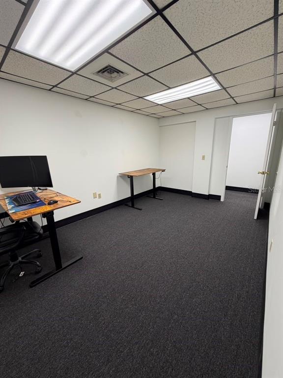 An office room with gray carpet, white walls, drop ceiling lights, and two standing desks — 2115 N 22ND STREET, TAMPA, FL