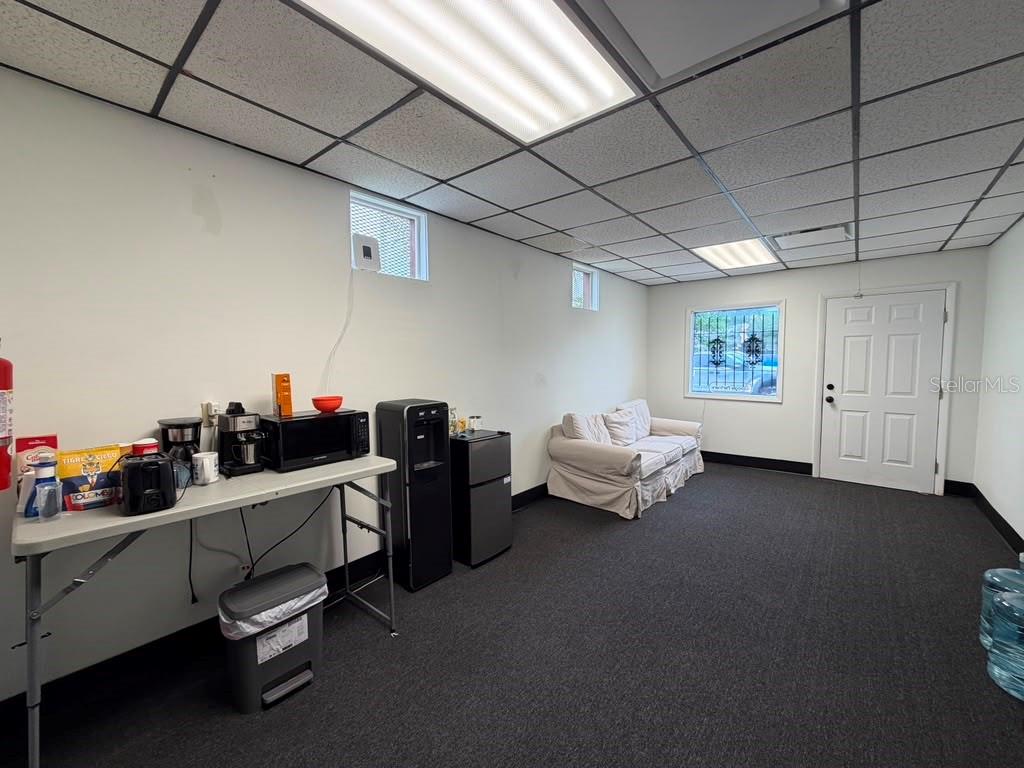 A breakroom features a folding table with appliances, a water cooler, a sofa, and carpeting — 2115 N 22ND STREET, TAMPA, FL