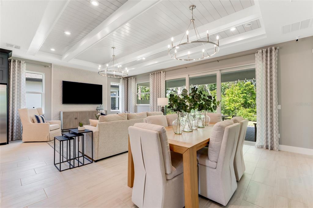 A bright open-concept living and dining area with a coffered ceiling and large sliding doors — 1214 CRESSWIND BOULEVARD, DELAND, FL