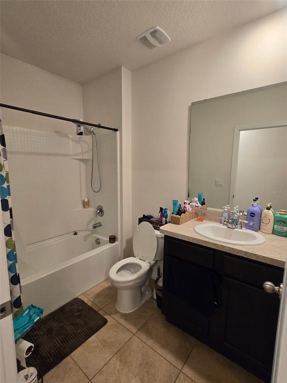 A bathroom features a tub-shower combination, a white toilet, and a dark wood vanity — 1760 CARNOSTIE ROAD, WINTER HAVEN, FL