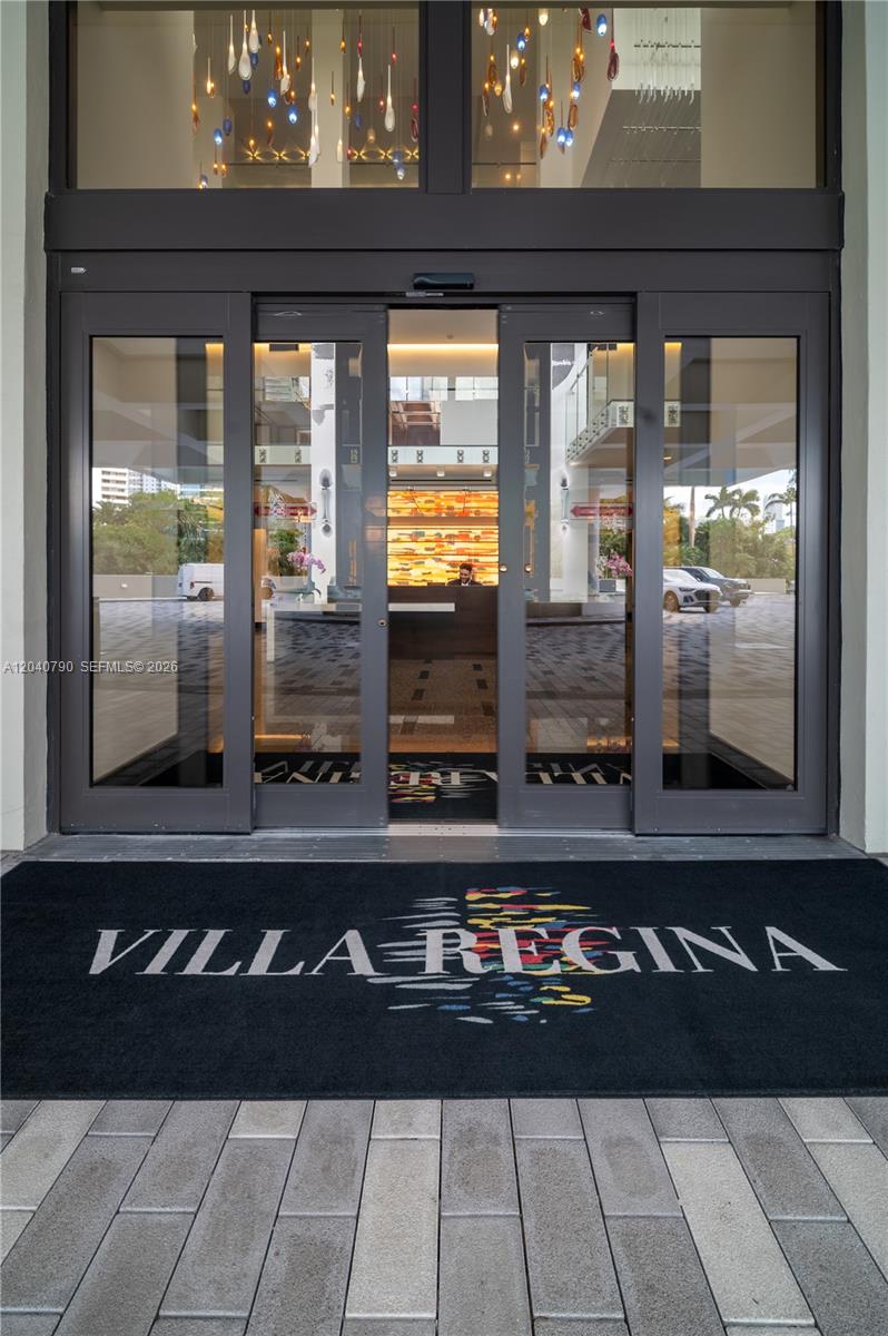 The entrance to Villa Regina features glass sliding doors and a branded floor mat — 1581 Brickell Ave, Miami FL 33129, MIAMI, FL
