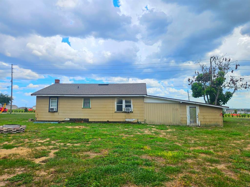 A single-story house with yellow siding and a shed-roof addition sits on a grassy lot — 507 FLORIDA AVENUE, DUNDEE, FL