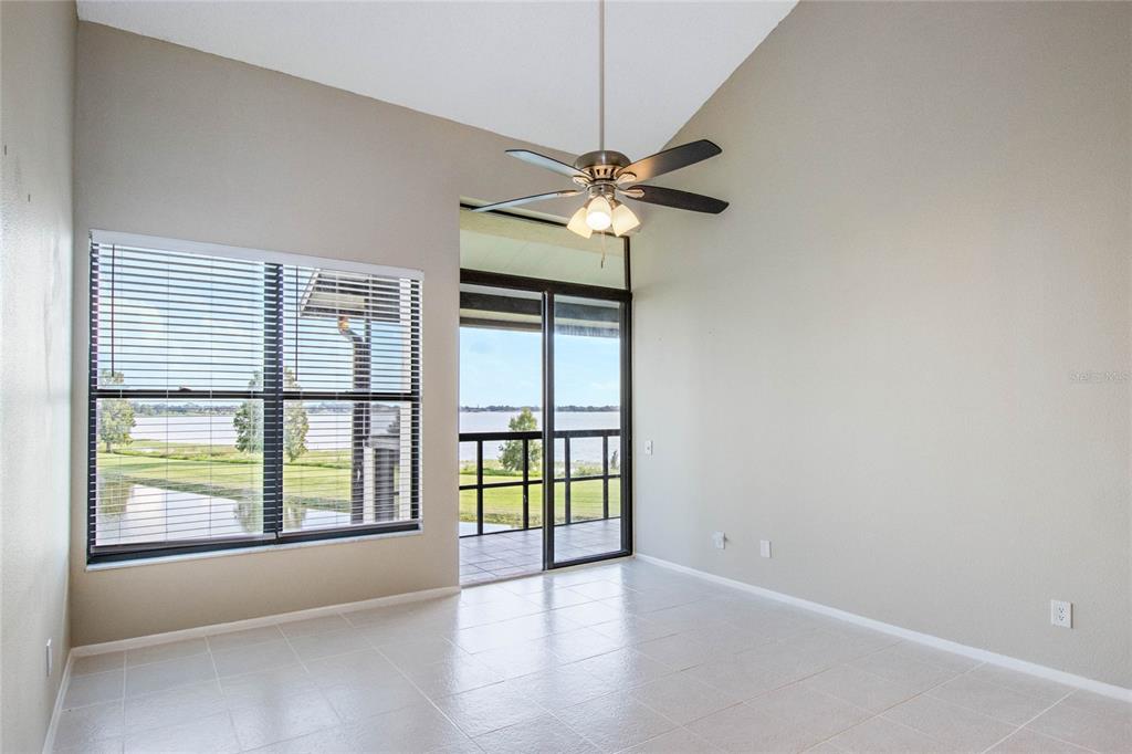 A room with tile flooring, a ceiling fan, a large window, and a sliding glass door — 410 LAUREL COVE WAY, WINTER HAVEN, FL