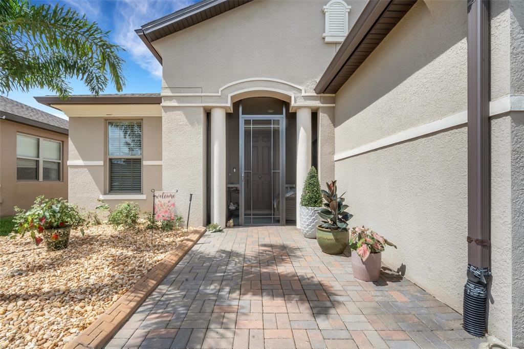 A paved walkway leads to a front entrance with two columns and a screen door — 519 VIGO STREET, DAVENPORT, FL