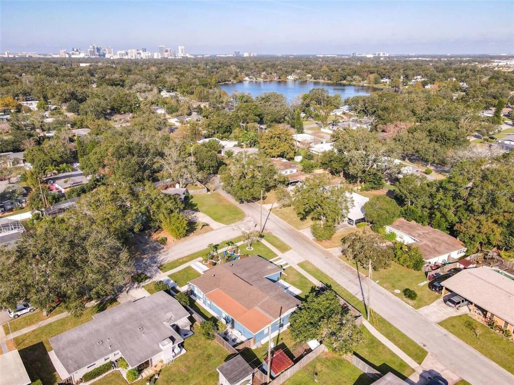 An aerial view shows a residential neighborhood with houses, trees, and a lake in the distance — 1245 CATALPA DRIVE UNIT 4, ORLANDO, FL